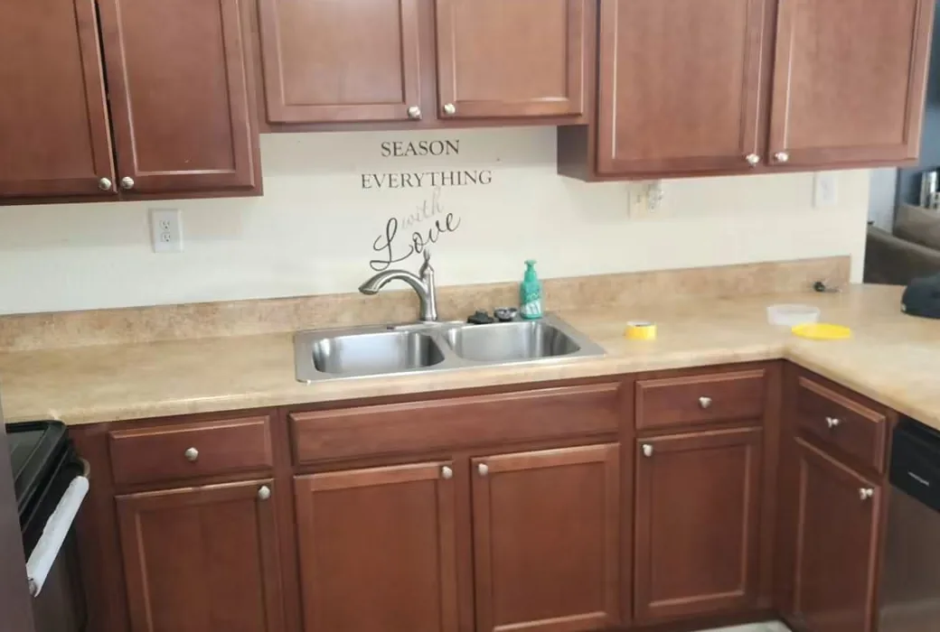 Kitchen with cherry-stained cabinet doors above and below a laminate countertop