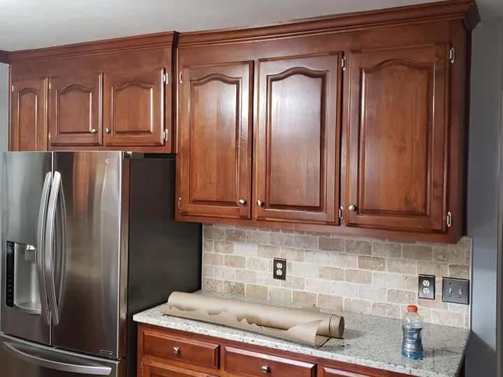 Kitchen with original cherry raised-panel cabinets, granite counter and stone backsplash