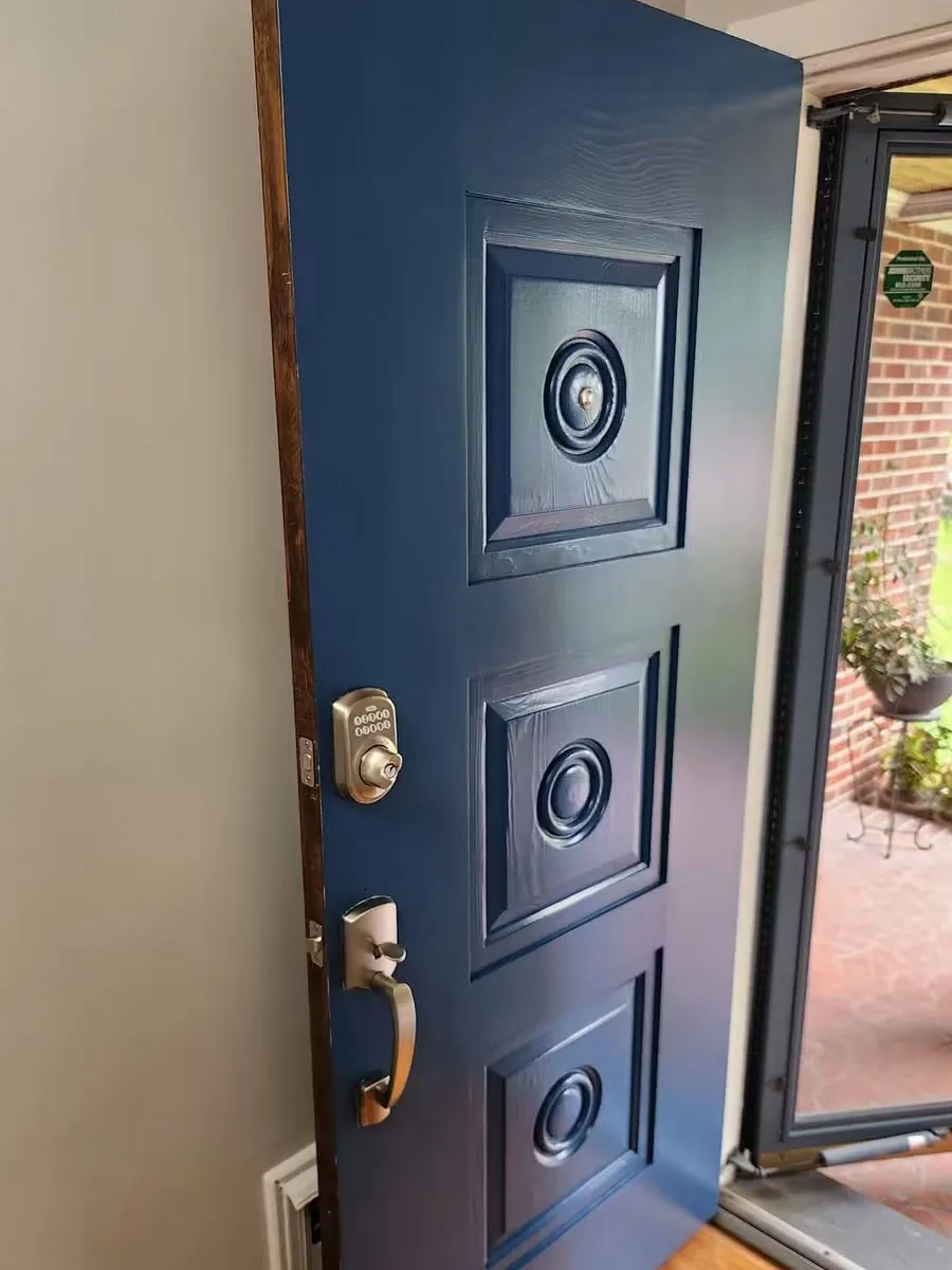 The same door finished navy, with the original brass medallions and handleset refitted