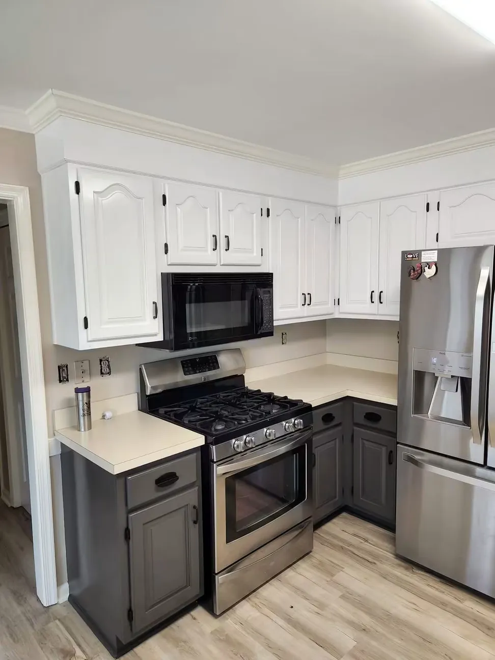 Oak wall cabinets refinished white over charcoal bases, cathedral doors and original hinges kept