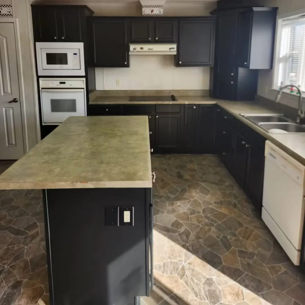 The navy kitchen from the island, wall ovens and countertops left in place around the refinished doors