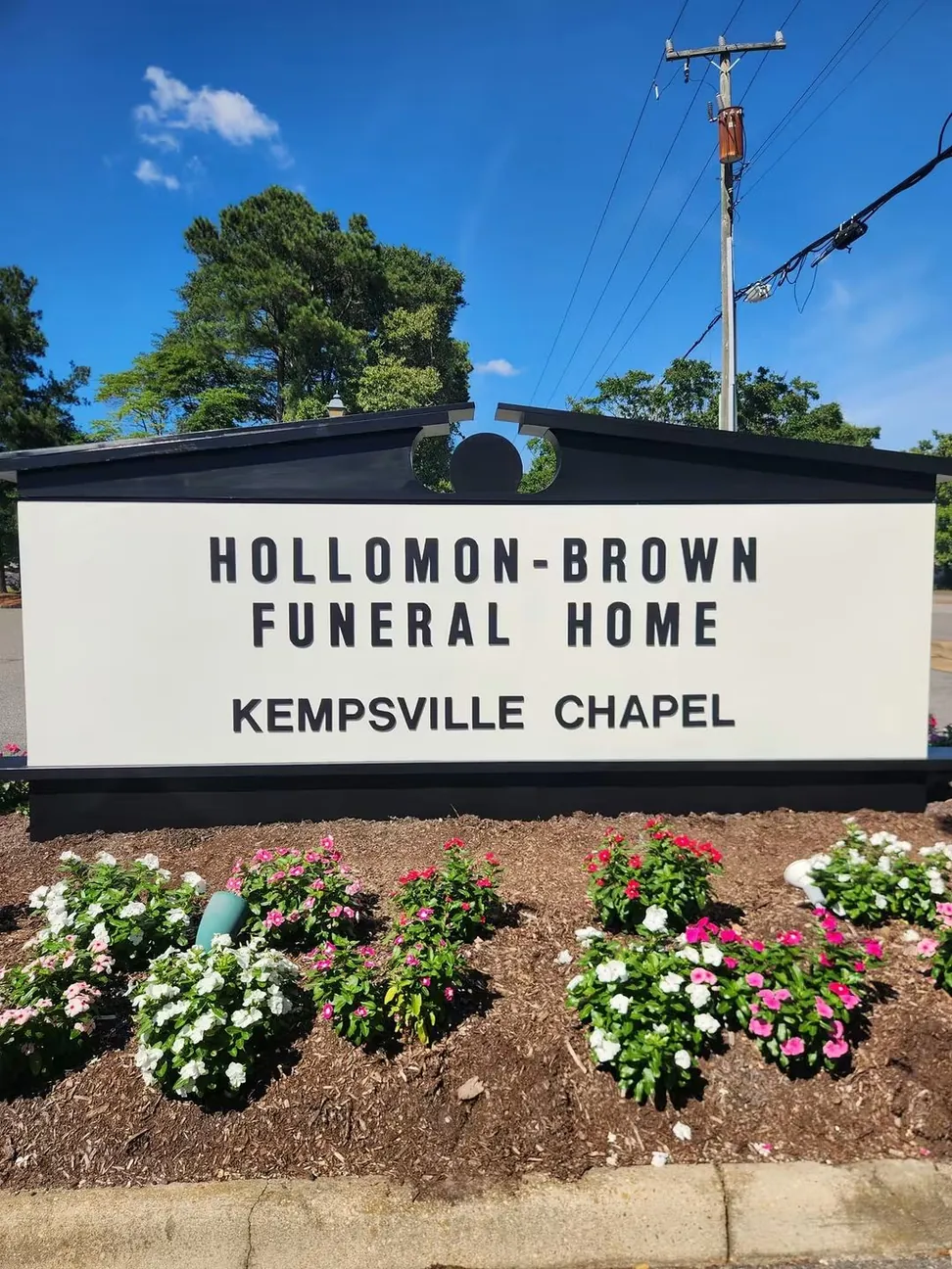 A funeral home monument sign after repainting, the face brought back to clean white and the cap and lettering in fresh black