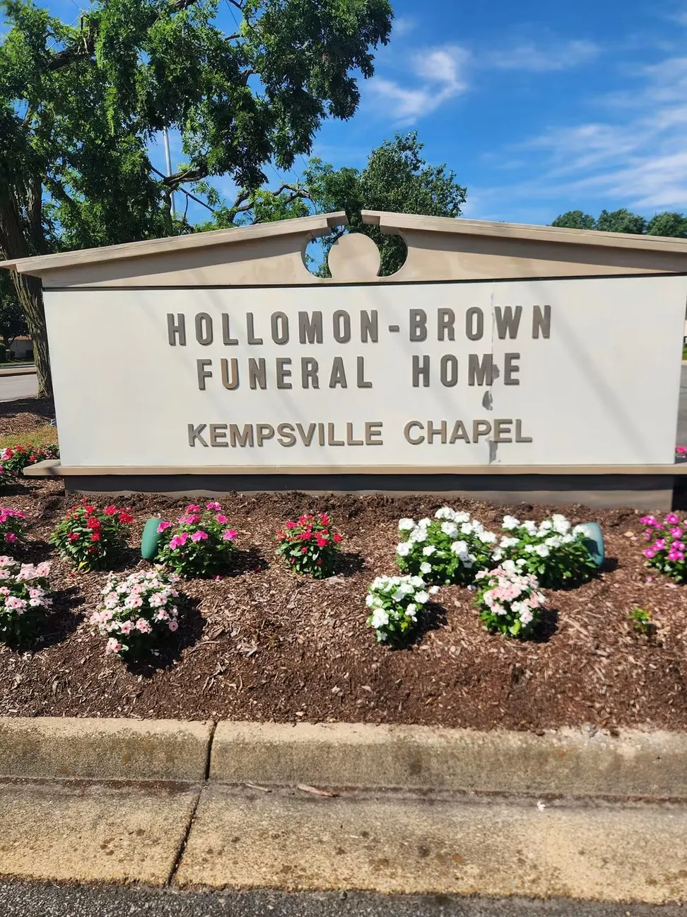 The same funeral home sign before work, the face chalked and streaked and the lettering faded to gray