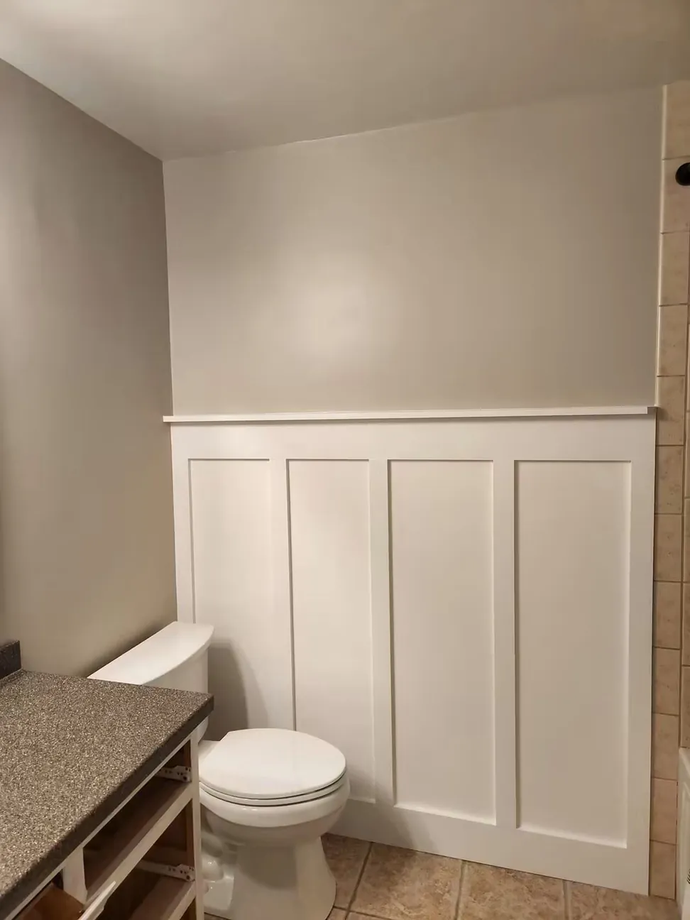 Bathroom board-and-batten paneling finished white, the battens filled and sanded flush before painting