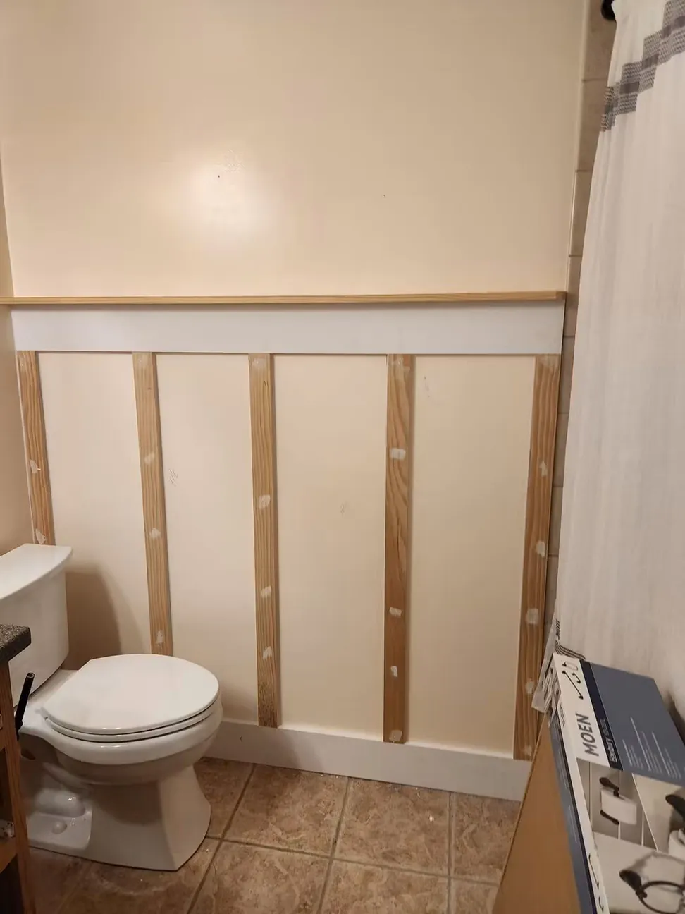 The same bathroom wall mid-job, battens fixed and the nail holes filled ready for priming