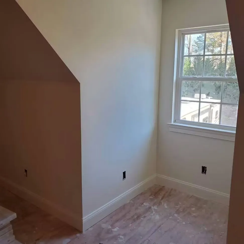 Dormer bedroom finished in a warm dusty rose, the sloped ceiling and knee wall carried through in one color