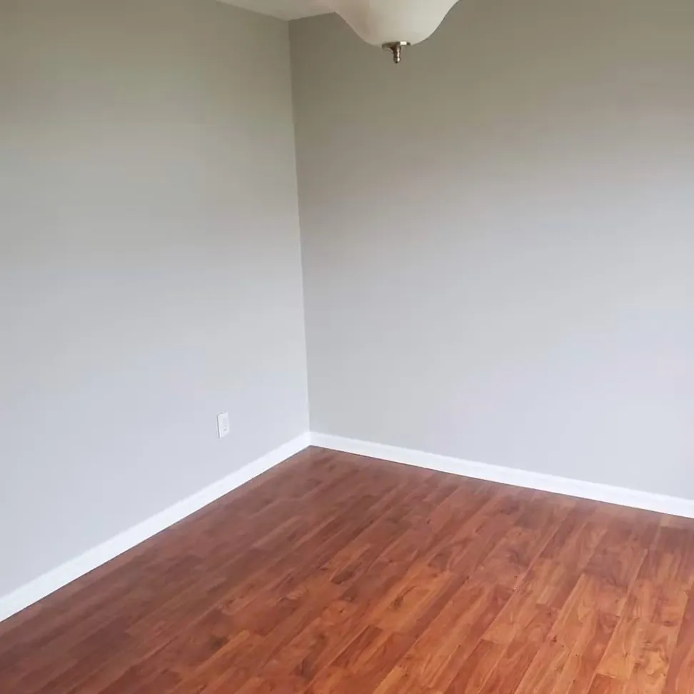Bedroom finished in a warm gray with the baseboard and window trim in white