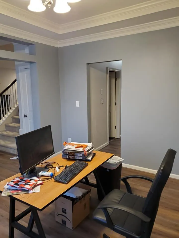 Gray dining room used as office with white crown molding and tray ceiling