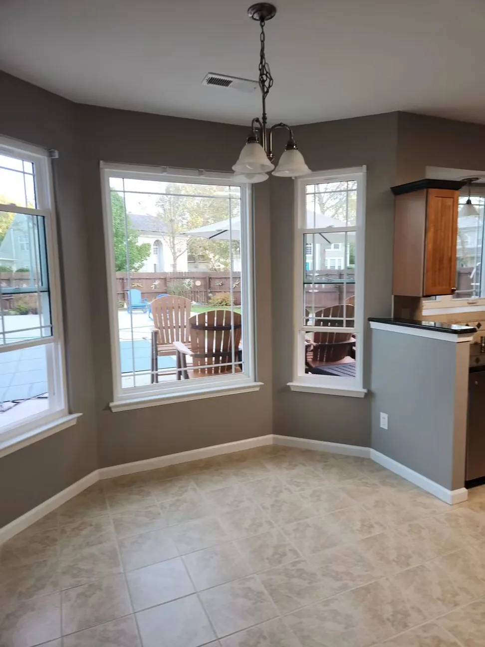 Bay-window dining nook repainted gray, the angled reveals and window boards cut in around the glazing