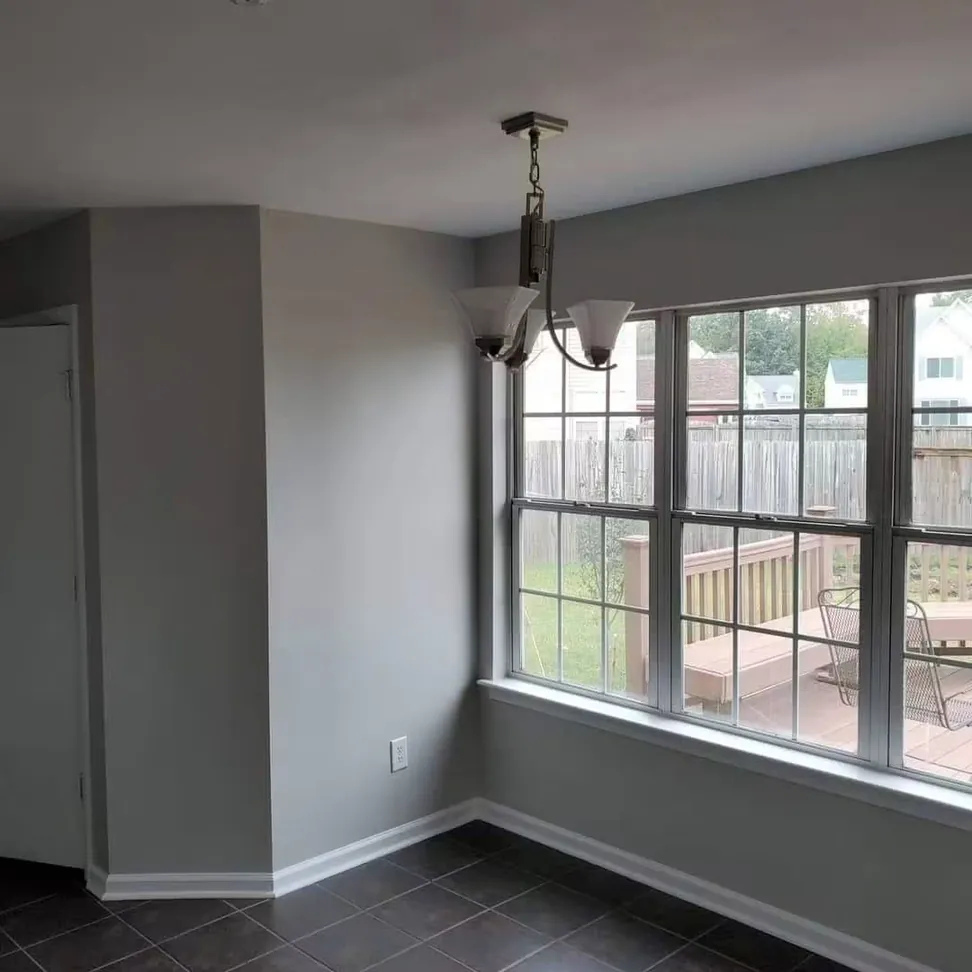 Dining room finished in gray, the window wall and returns cut in around a full-width run of glazing