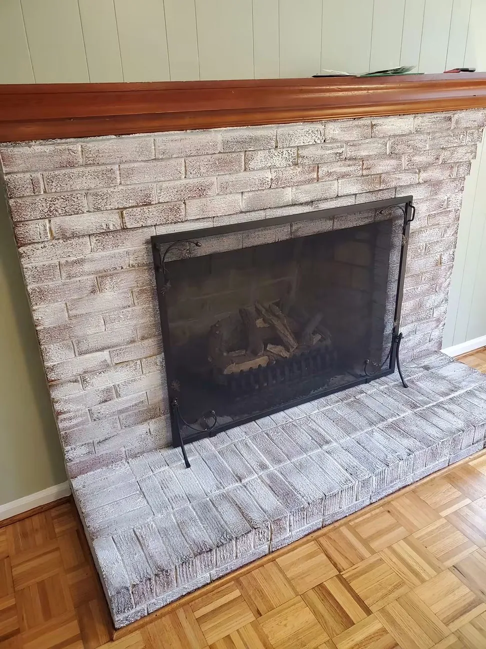 Brick fireplace and hearth limewashed to a soft white, the mortar joints left showing through