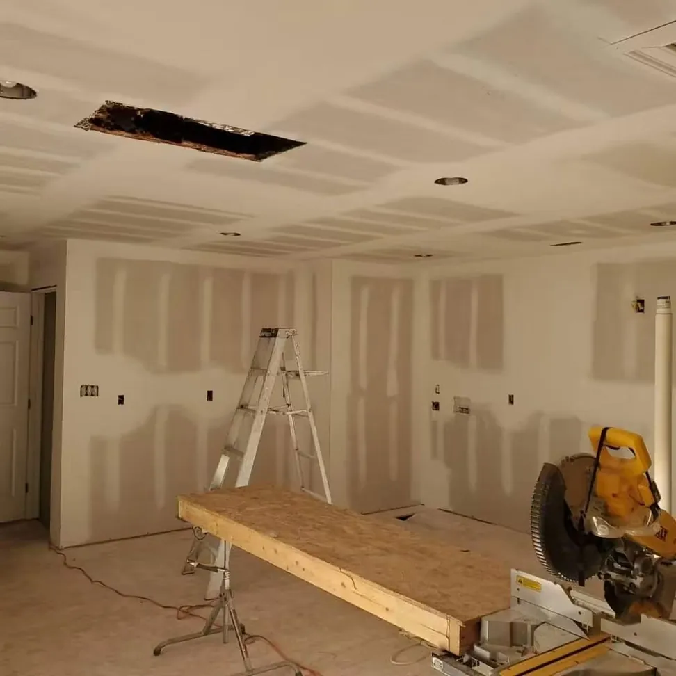 A new-build great room at drywall stage, joints taped and set before any primer goes on
